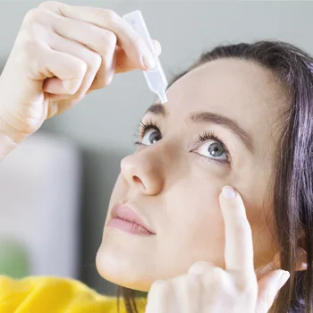 Eye Doctor Plainfield IL Healthy Tears BOX A young woman applying eye drops into her eye while she holds her eye open